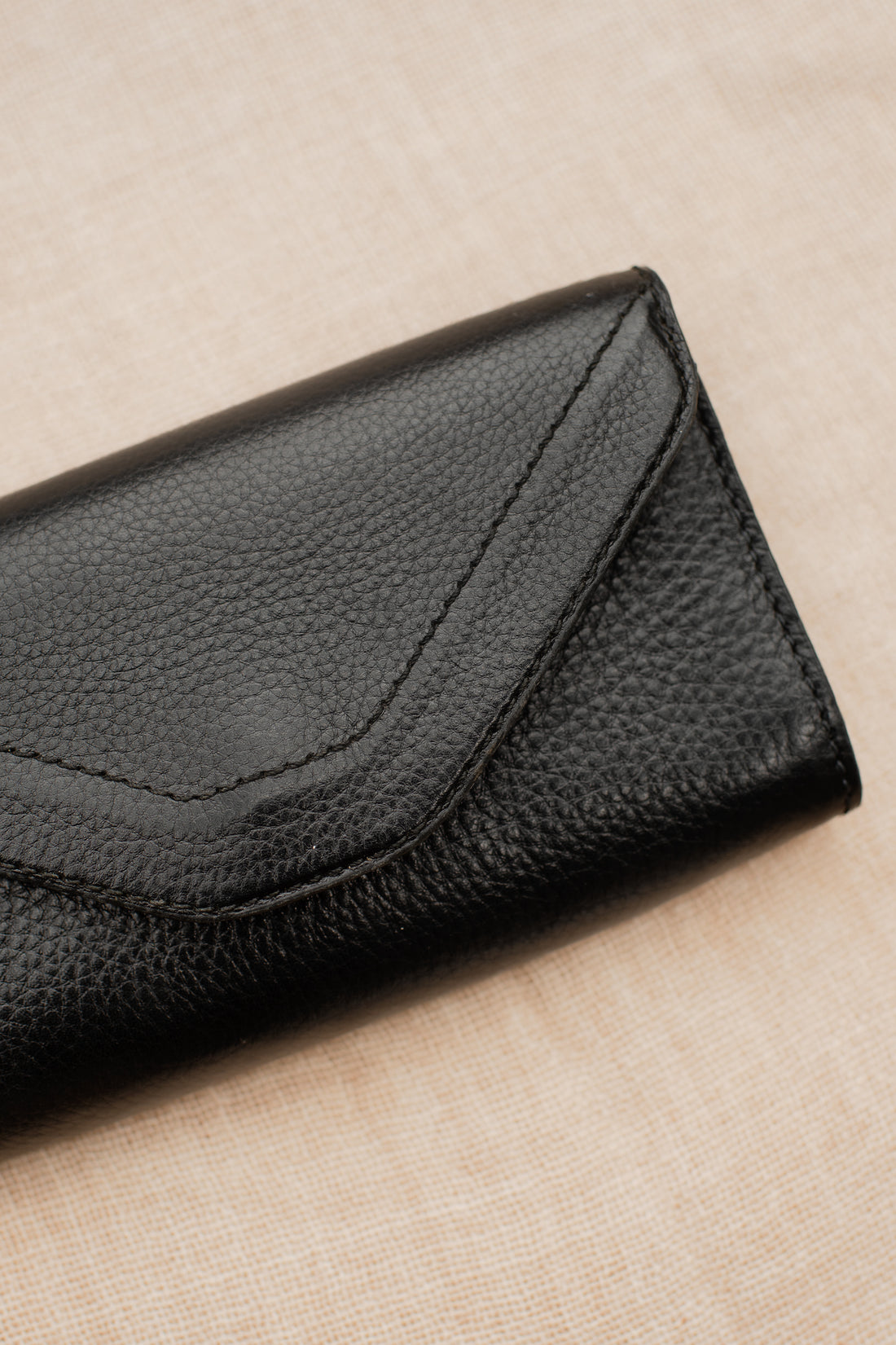 Detail of black pebbled leather equestrian belt bag and fine stitching.